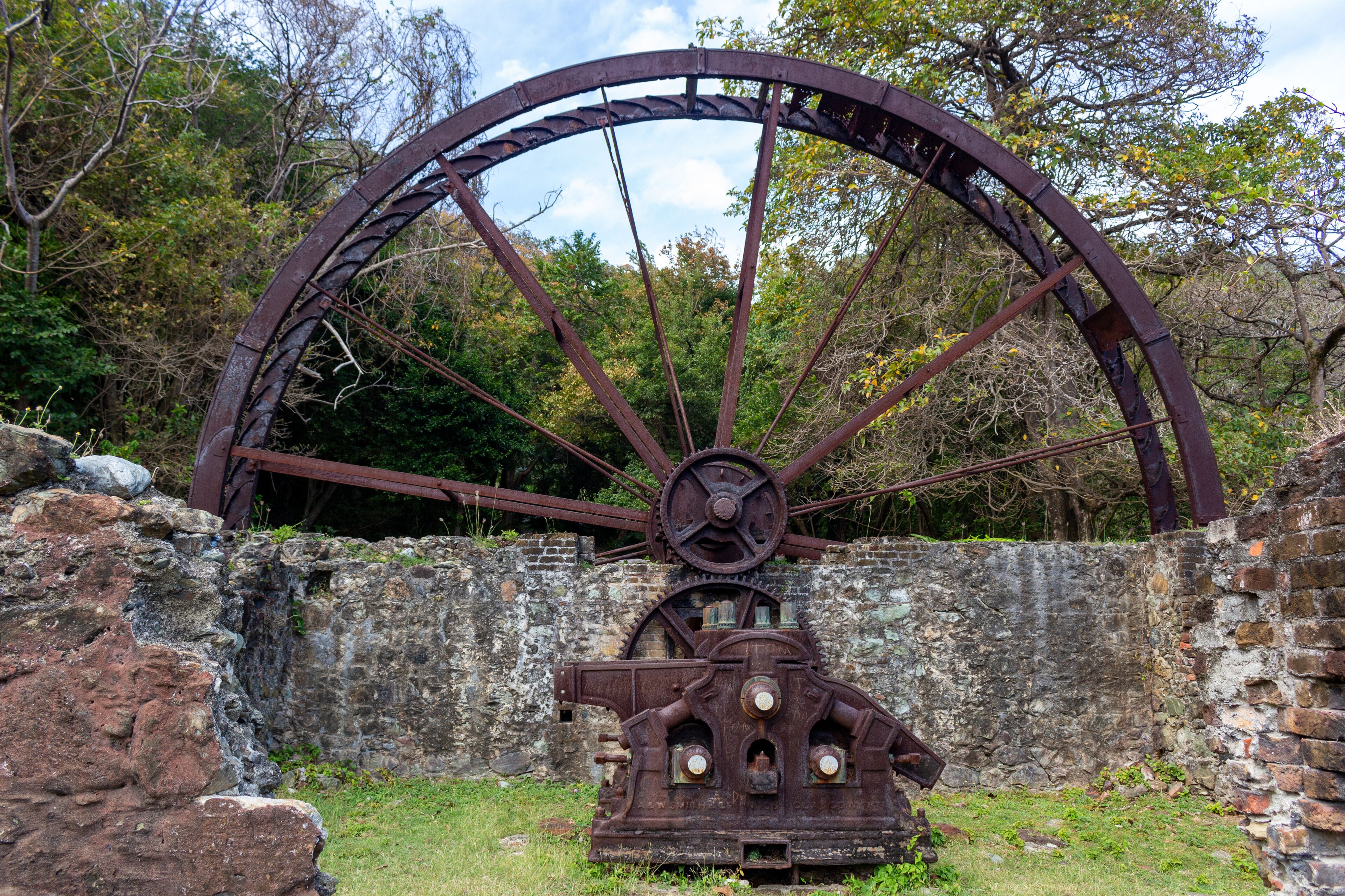Historic Speyside water wheel surrounded by tropical forest ruins in Tobago, Trinidad and Tobago