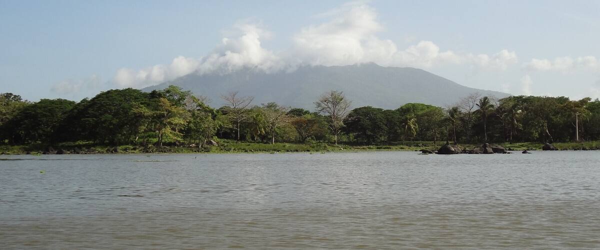 A calm lake with a mountain in the background.