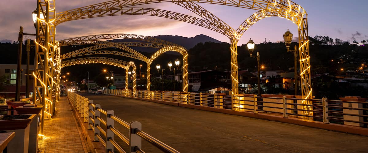 A bridge with illuminated arches at dusk.