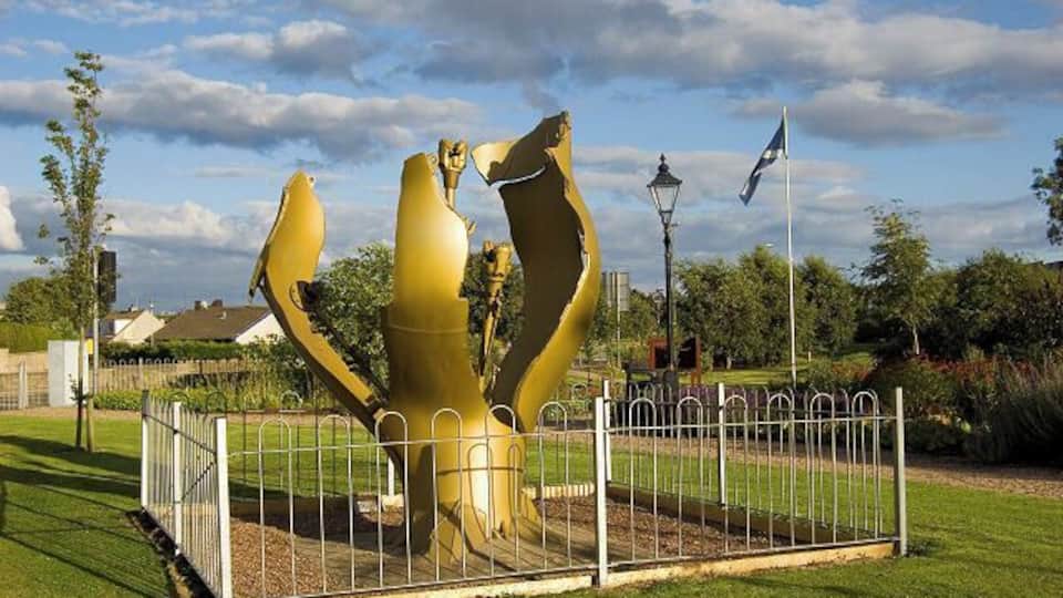 Dyce Community Garden, near to Dyce, Aberdeen, Great Britain. Dyce Community Garden. Until a few years ago this was a patch of waste ground. In the foreground is a sculpture based around a ruptured oil pipeline. The Scottish saltire proudly flies in the background.