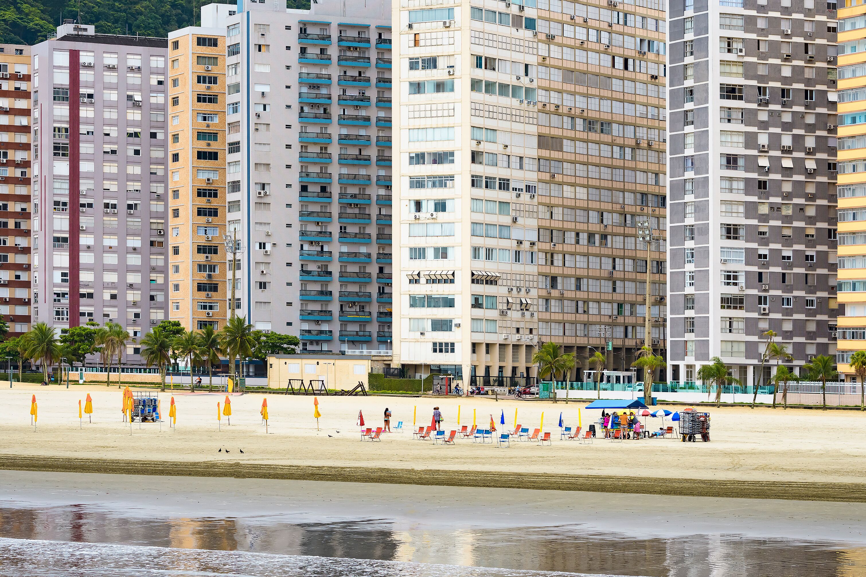 View of a beach of Santos SP Brazil. Jose Menino beach, people on the sand and the buildings on background. Brazilian coastal city.