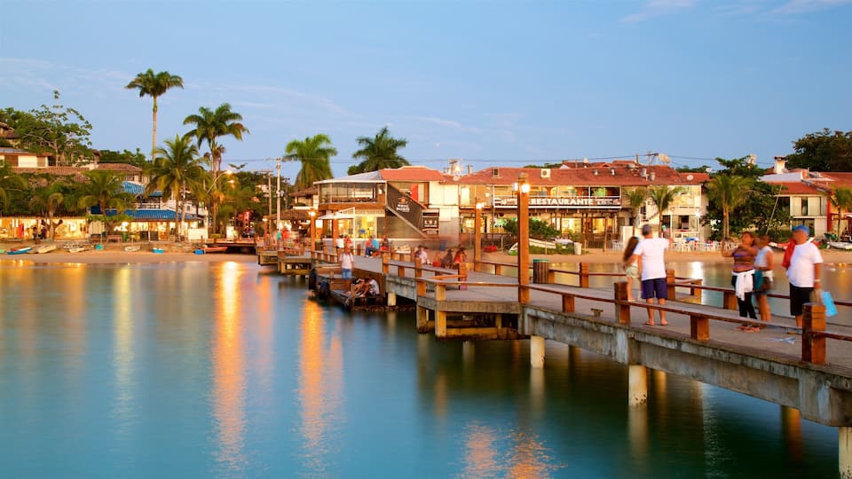 Buzios featuring a coastal town and general coastal views as well as a small group of people