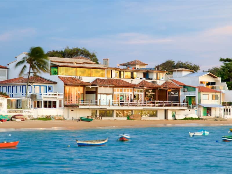 A coastal town with colorful buildings, a beach, and several boats.