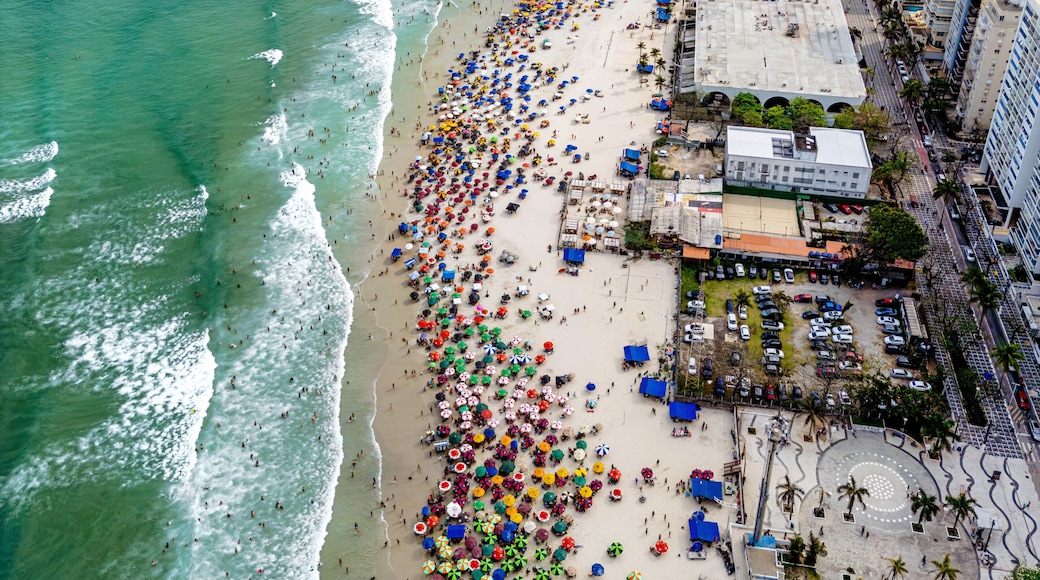 Vista aérea de dia ensolarado com muitos turistas na Praia de Pitangueiras no litoral paulista, Guarujá.