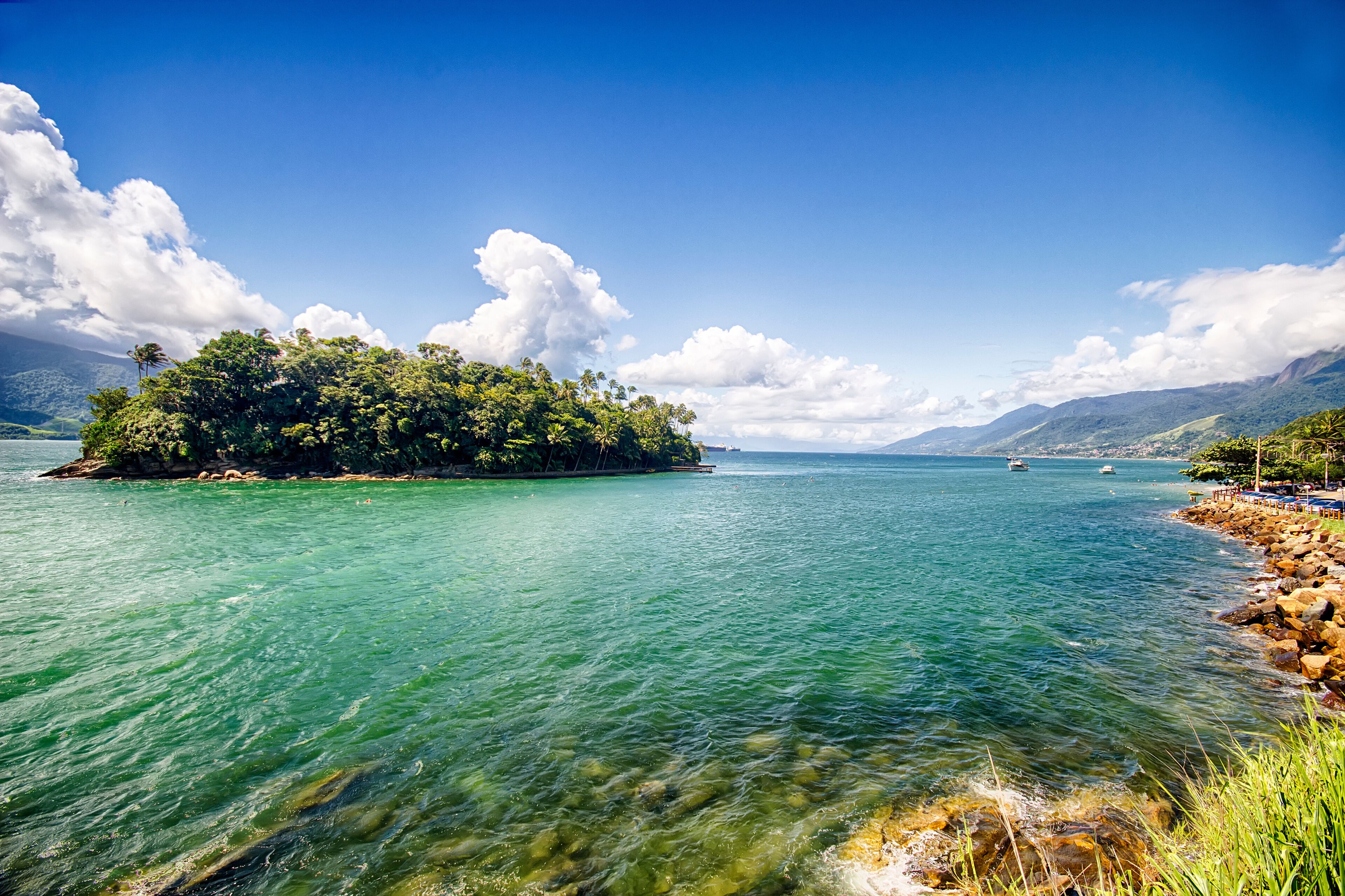 Island of goats, Ilha das cabras, on mid channel between Sao Sebastiao and Ilhabela - São Paulo, Brazil - seen from Ilhabela on a sunny day with sky with clouds - Panorama photo