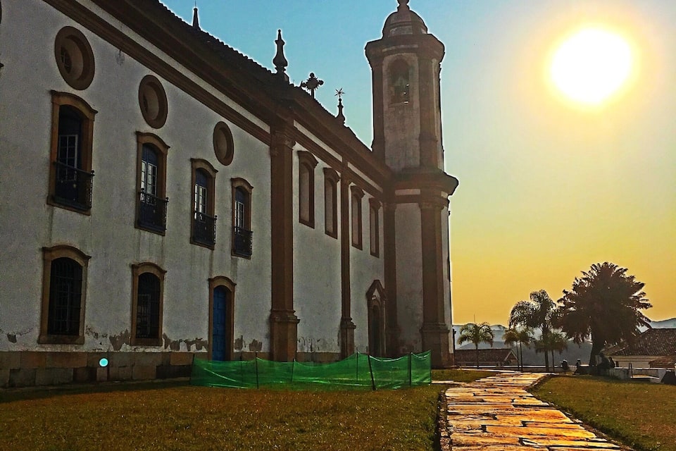 A white building with a bell tower and a clear sky.