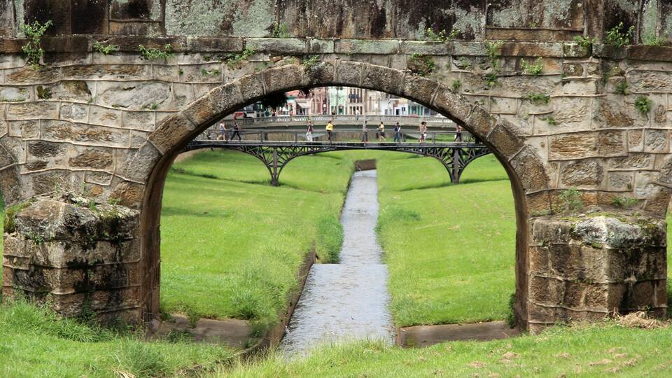 An old stone bridge with a grassy pathway underneath.