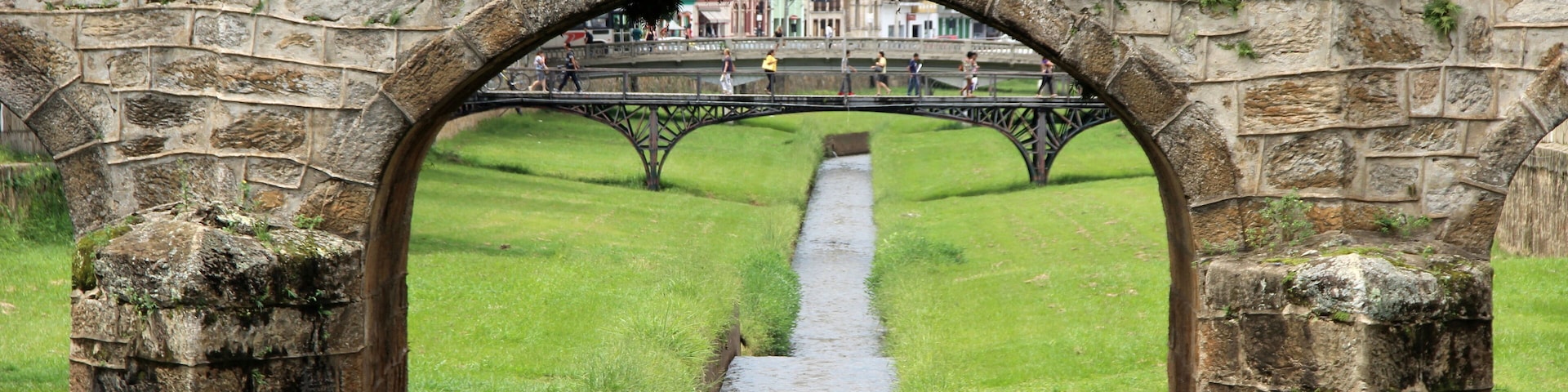 An old stone bridge with a grassy pathway underneath.