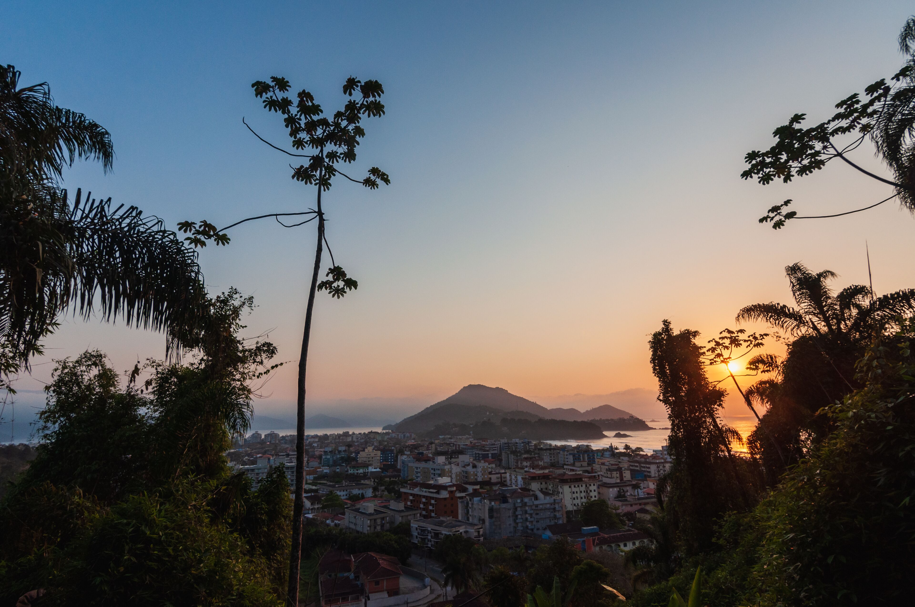 Sunrise at Ubatuba sea with an aerial view of the city among coastline trees and vegetation