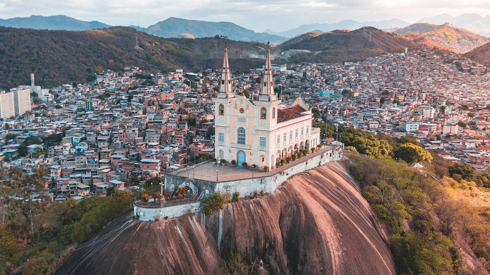 A church on a hill overlooking a densely packed city.