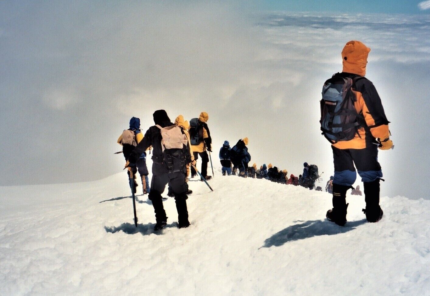 A group of hikers ascending a snowy mountain.