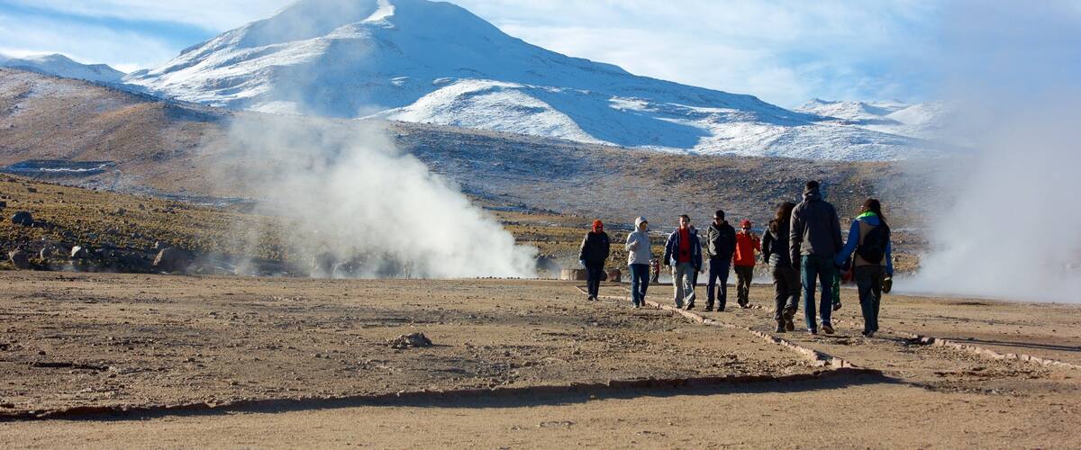 El Tatio geysirfelt fasiliteter samt fjell og ørkenutsikt i tillegg til en liten gruppe med mennesker
