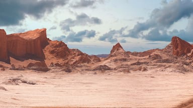 Paisaje desértico con un camino de tierra que atraviesa terreno rocoso y montañas.