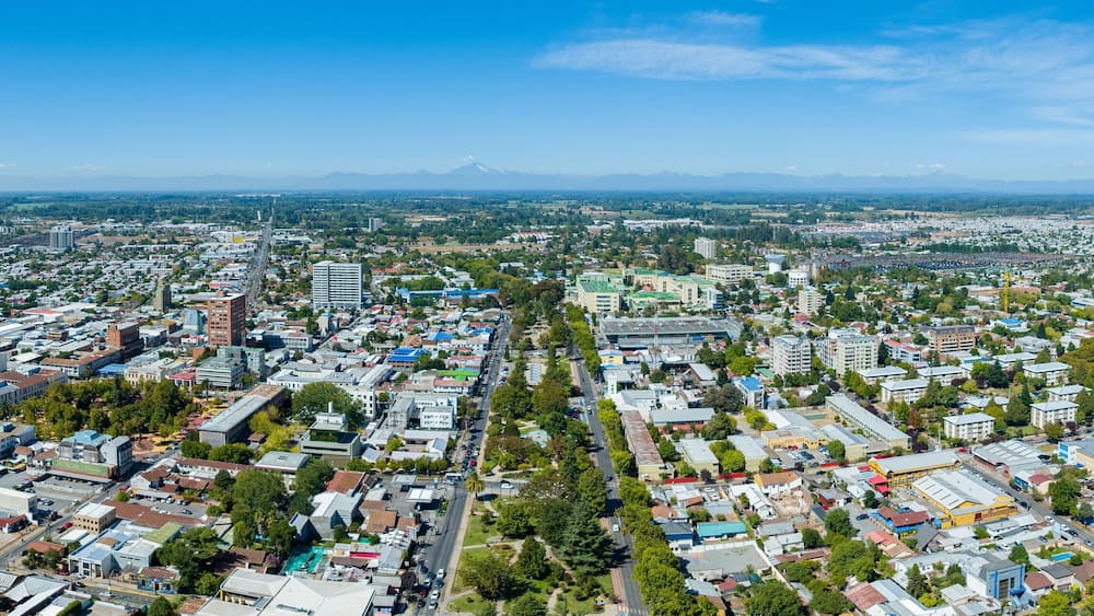 Une vue urbaine avec une montagne imposante en arrière-plan.