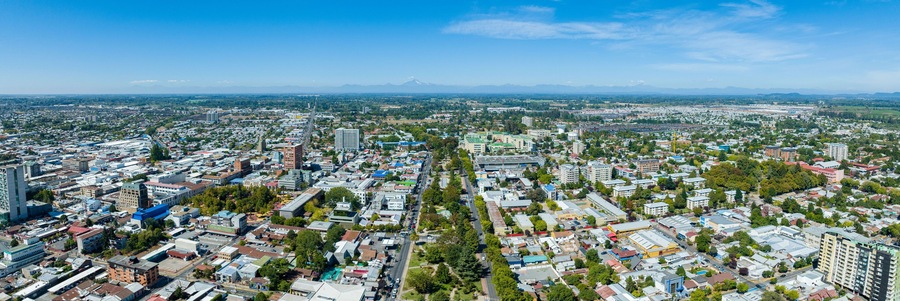 A cityscape with a prominent mountain in the background.