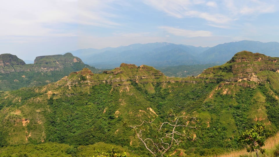 A mountainous landscape with green hills and rocky outcrops.