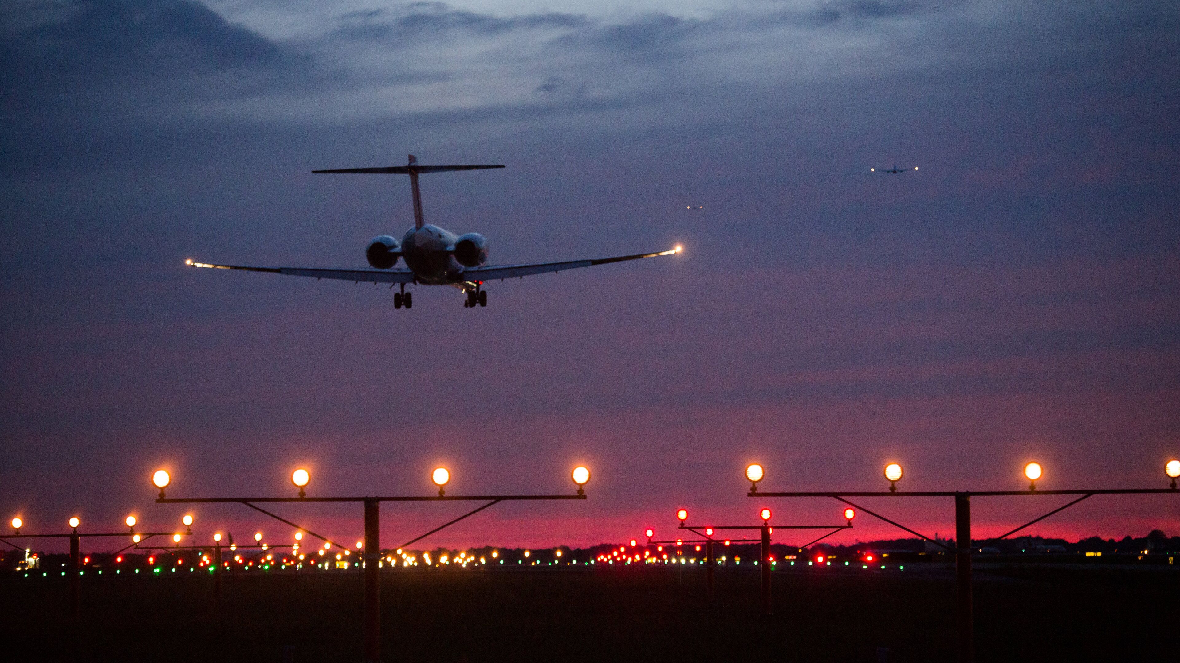 An airplane landing at night with runway lights visible.