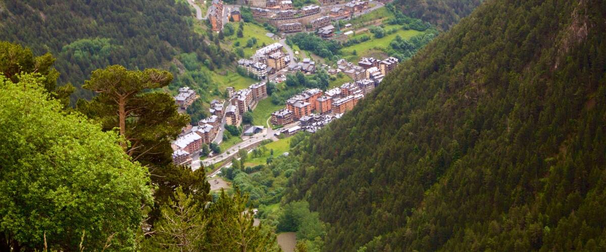 A mountainous village with terraced buildings and a winding road.