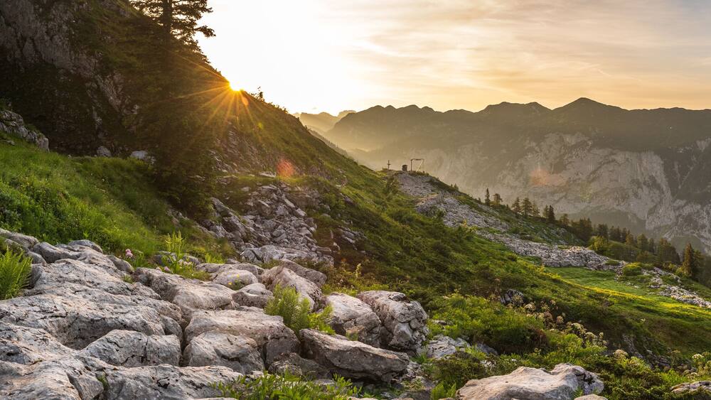 Sonnenaufgang am Loser im Ausseerland im Frühsommer mit einer Alm im Vordergrund und Blick in die Weite