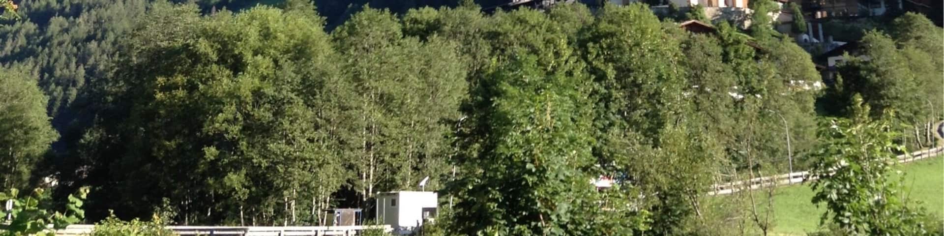 A church surrounded by lush green hills and a clear blue sky.
