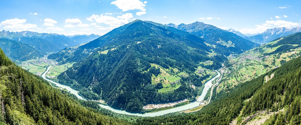 A mountainous landscape with a river winding through a valley.