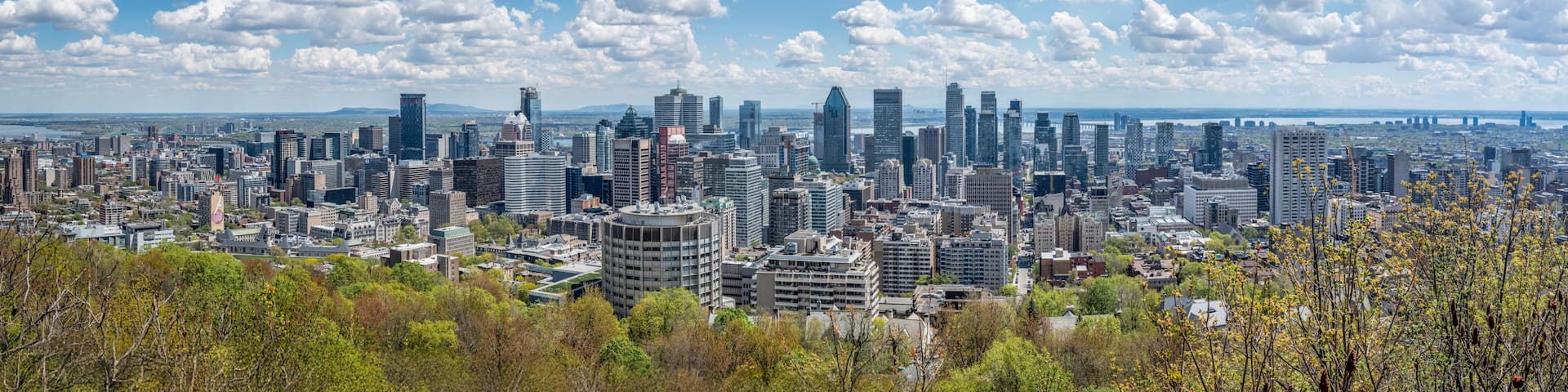 A dense urban skyline with modern high-rise buildings, a river in the background, and a bridge spanning the river.