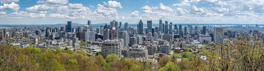 A dense urban skyline with modern high-rise buildings, a river in the background, and a bridge spanning the river.
