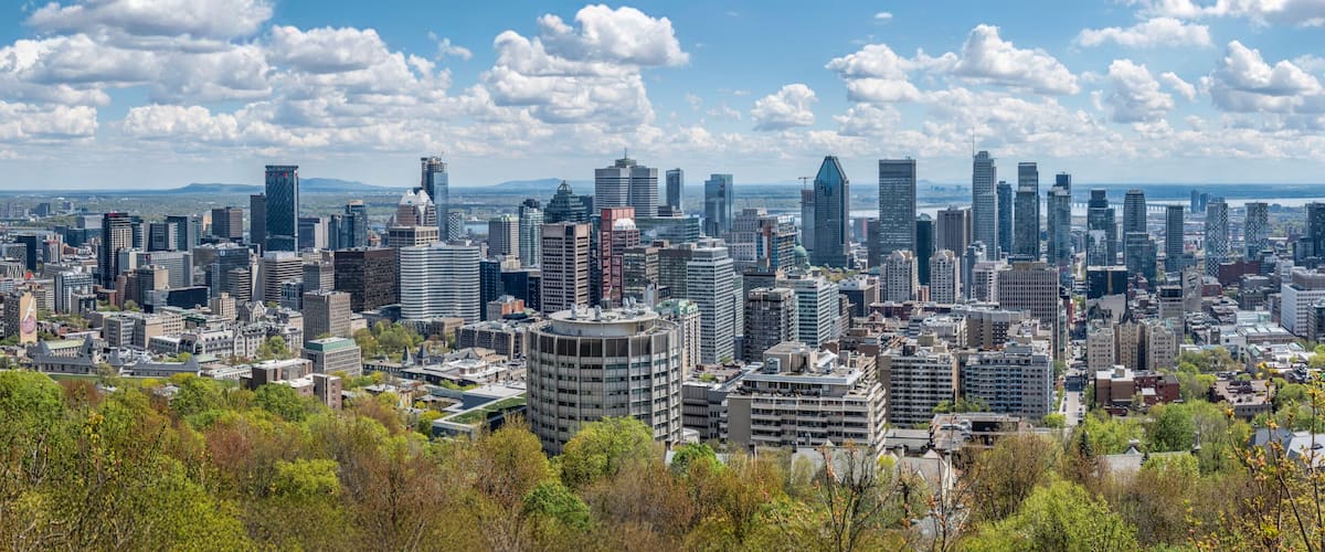 A dense urban skyline with modern high-rise buildings, a river in the background, and a bridge spanning the river.