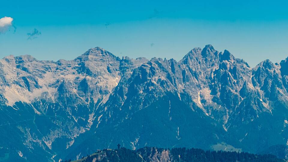 A range of snow-capped mountains under a clear blue sky.