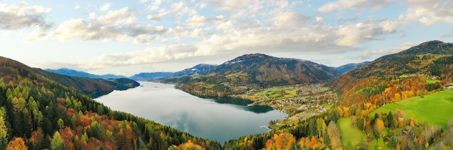 A lake surrounded by mountains and autumn-colored trees.