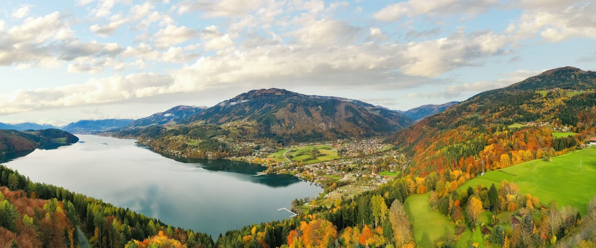 A lake surrounded by mountains and autumn-colored trees.