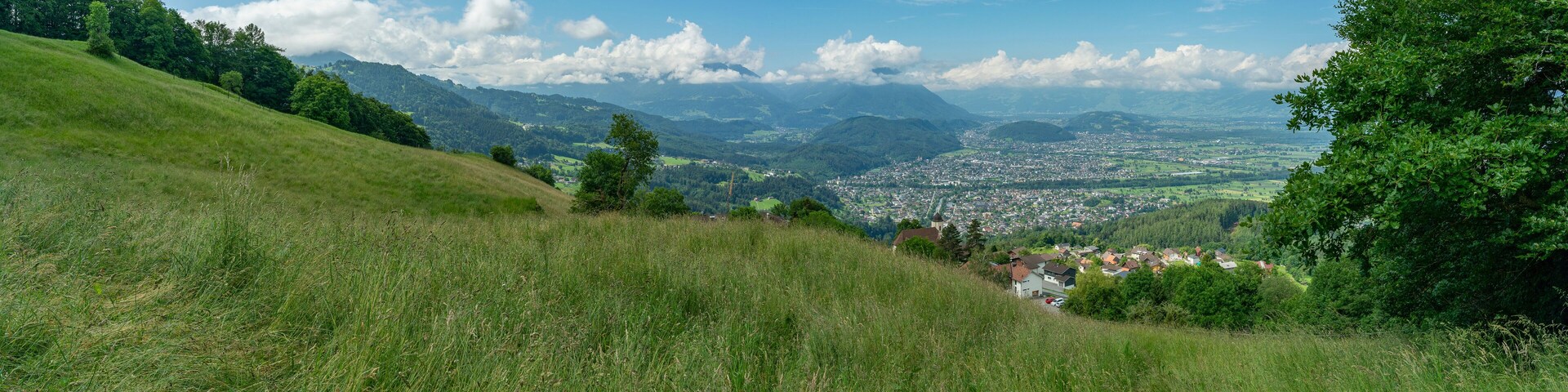 Panorama vom Rheintal bei Feldkirch, Rankweil und Dafins. sonnige Aussicht über Täler, Hügel und Berge, Wiesen und Wälder, Dörfer und Stadt. Sommer in Vorarlberg
