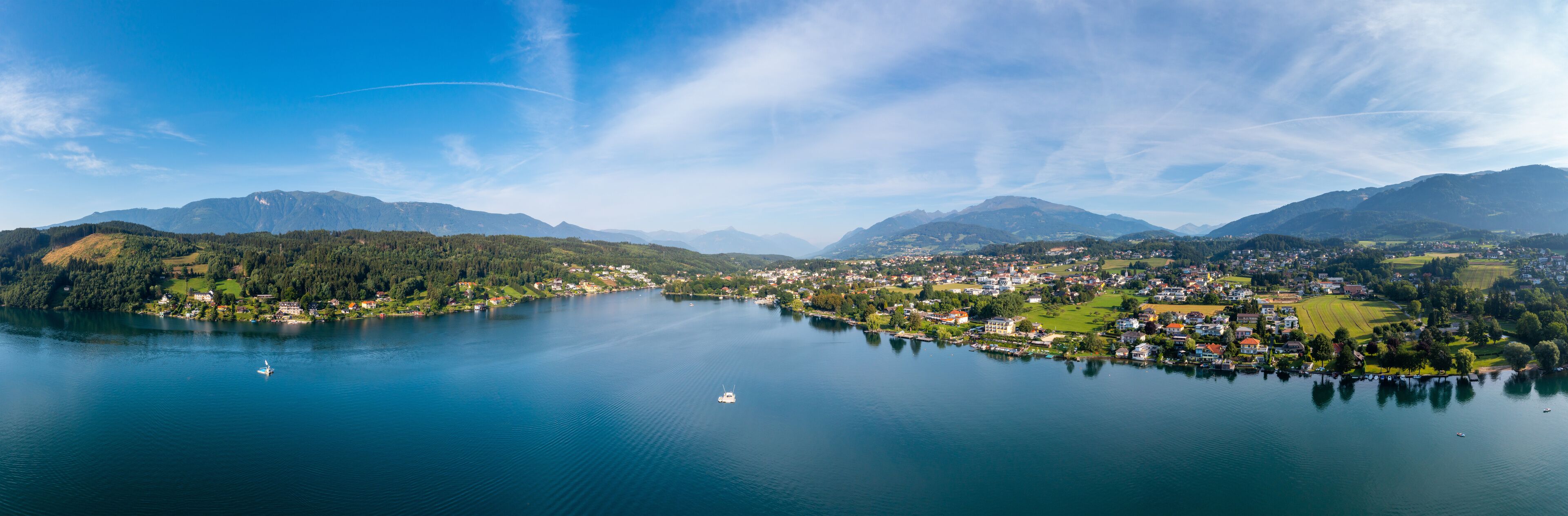 A lake surrounded by mountains and a small town.