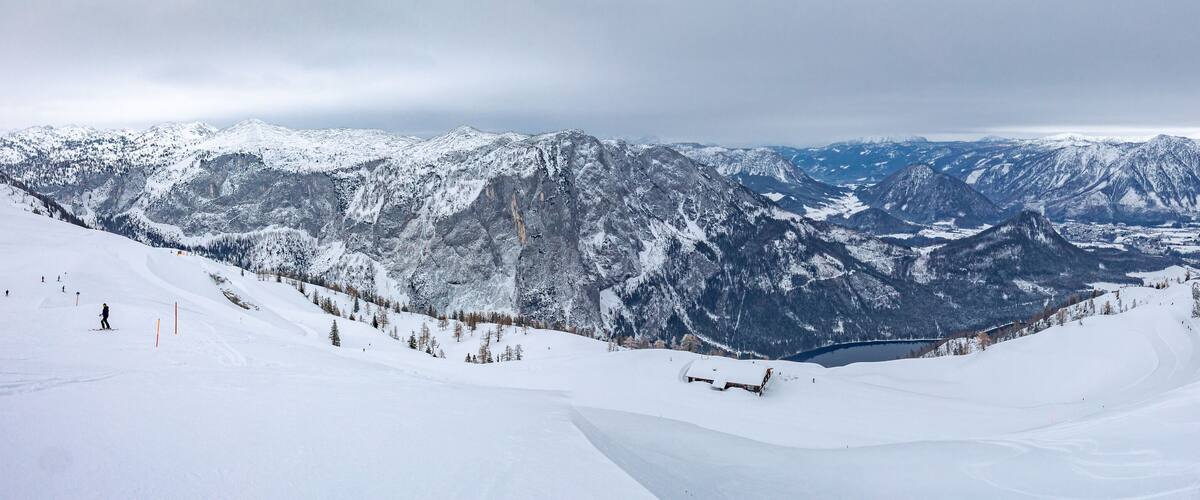 A snow-covered mountain landscape with a ski resort and a lake.