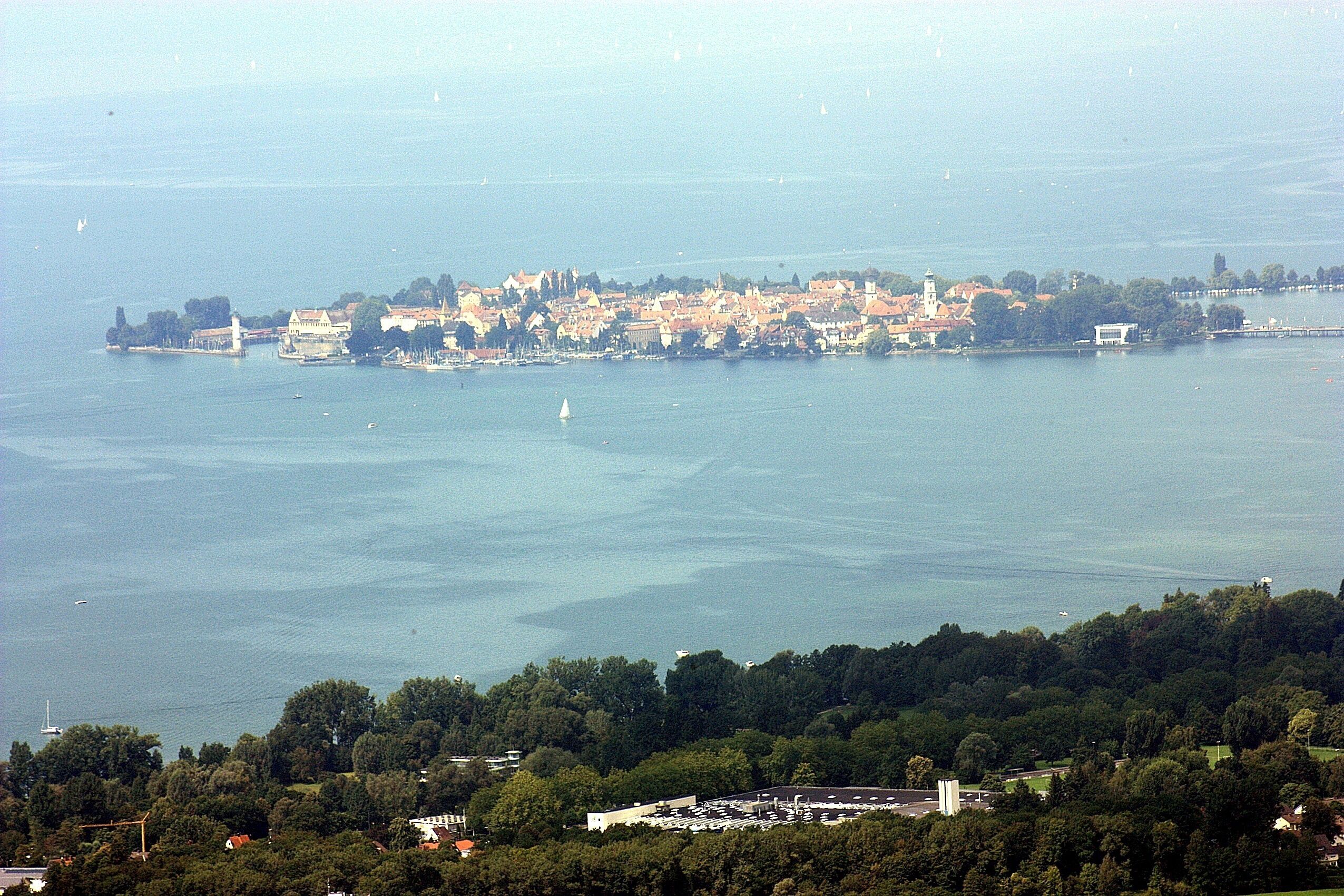 A coastal town with a harbor, boats, and a lighthouse.