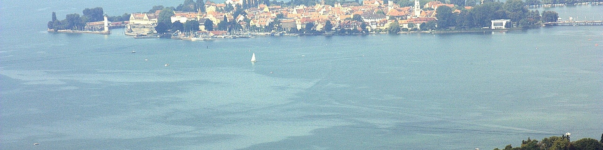 A coastal town with a harbor, boats, and a lighthouse.