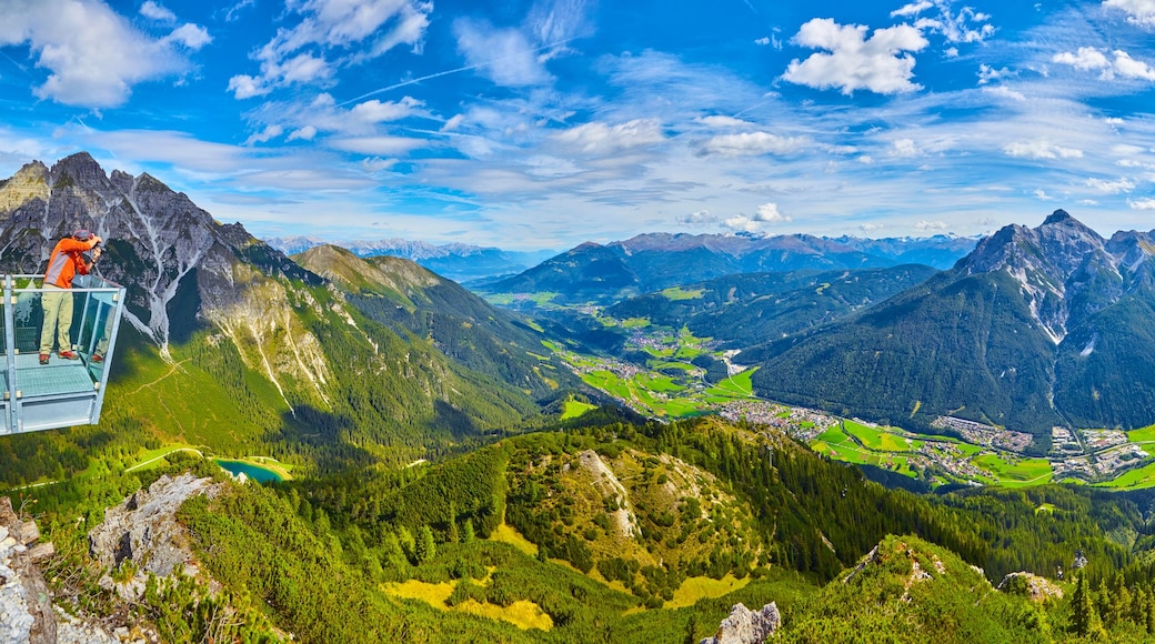 A mountain landscape with a glass bridge, a valley, and a town.