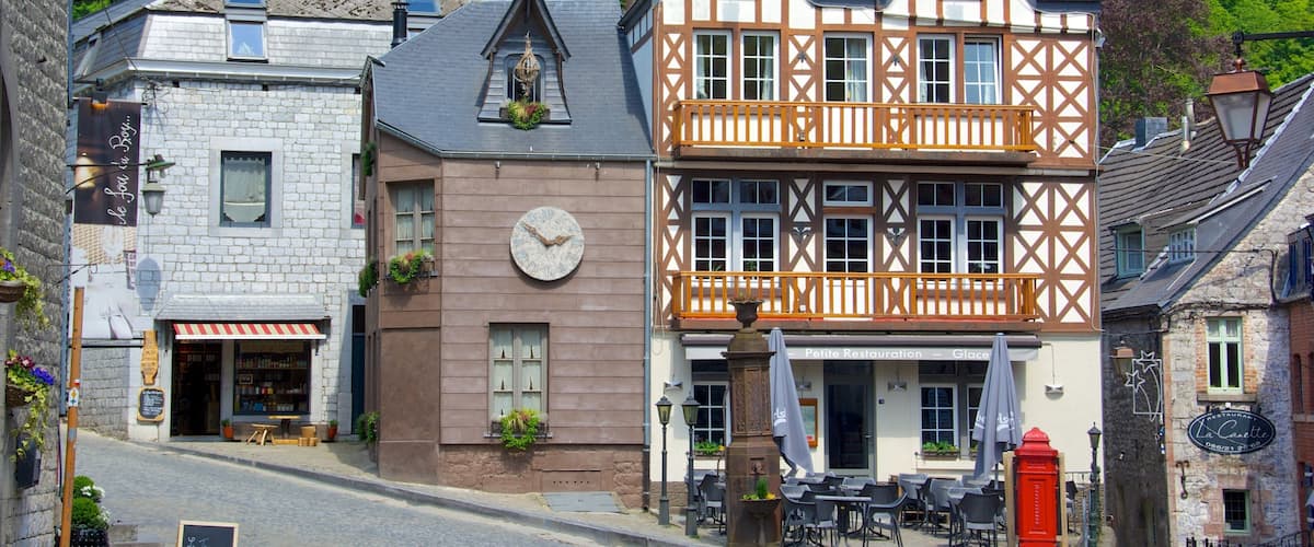 A historic European town with traditional architecture, including a clock tower and a restaurant named "La Cantette."