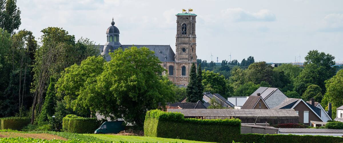 Landscape view over green fields and the Abbey tower of Grimbergen, Flemish Brabant, Belgium