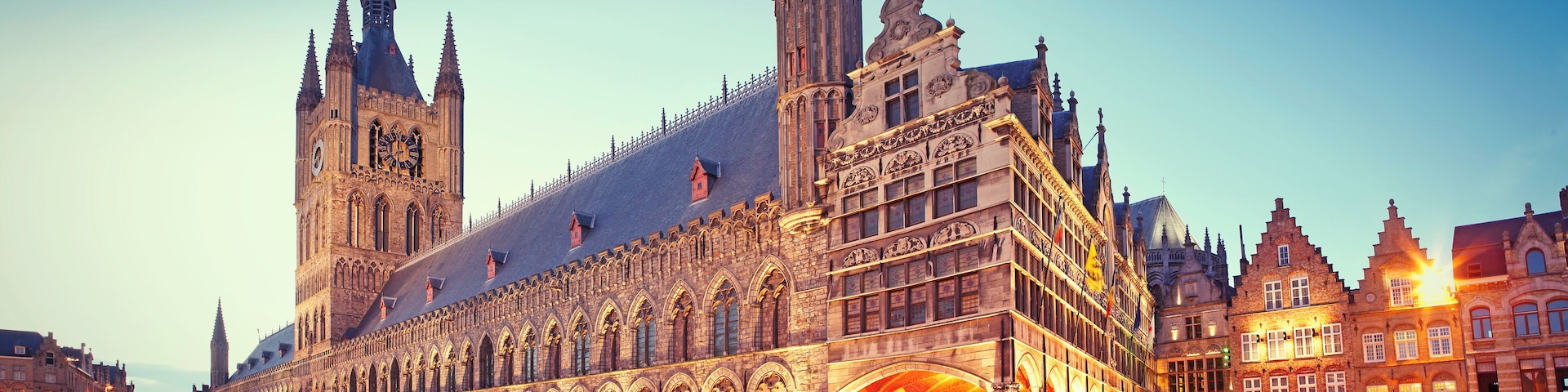 Un edificio histórico con arquitectura gótica, que incluye arcos apuntados y una torre del reloj.