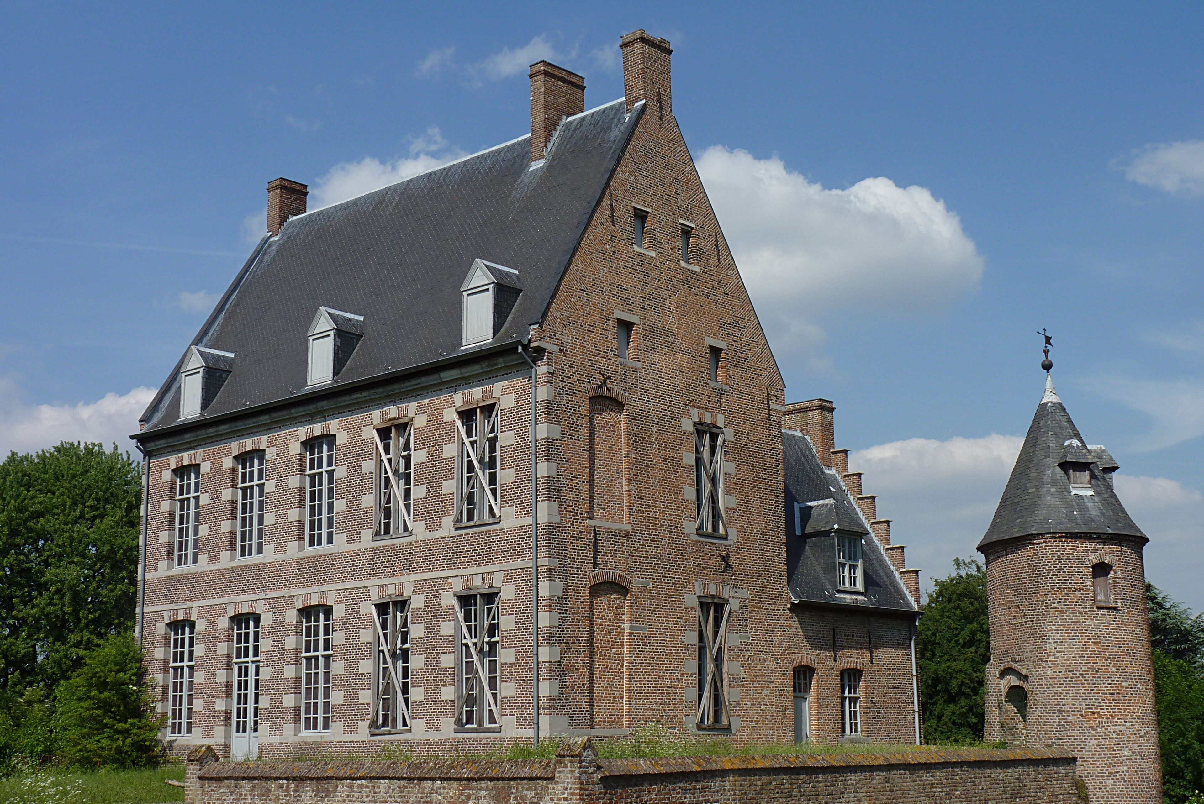 A large brick building with multiple windows and a tower.