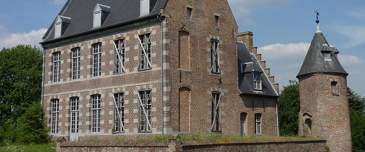 A large brick building with multiple windows and a tower.