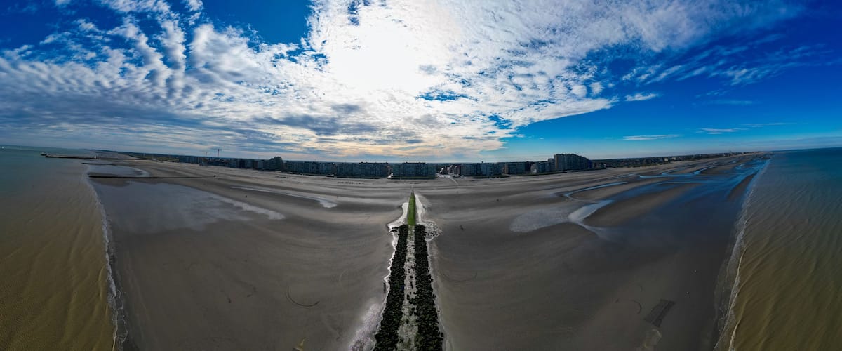 Nieuwpoort, Belgium, October 5th, 2024, A breathtaking view of a coastal pathway under colorful skies and dynamic clouds that inspires wanderlust