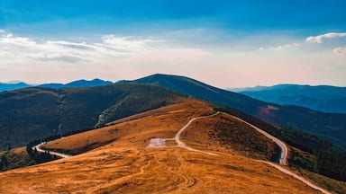 A mountain landscape with a winding road and a clear sky.