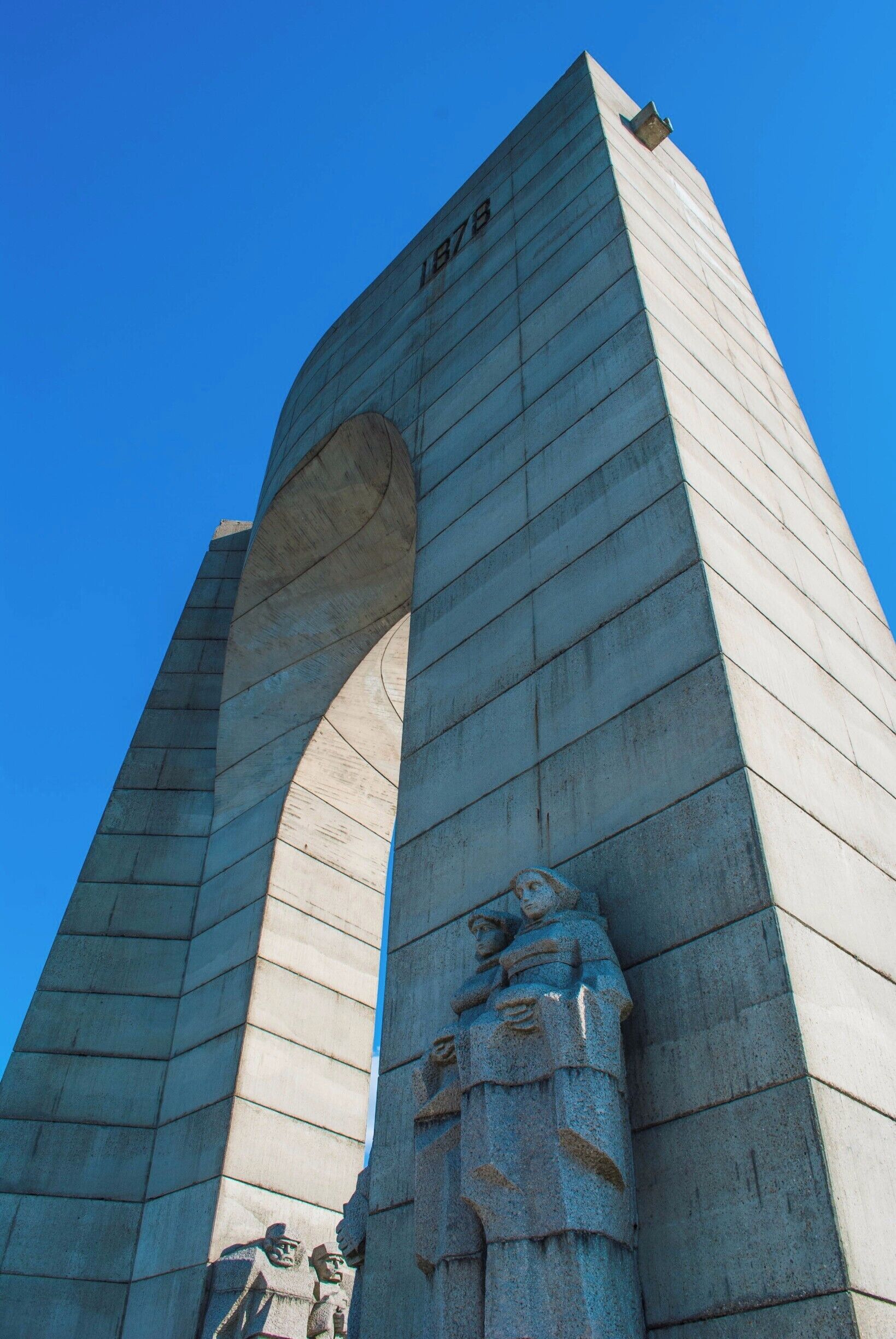 A tall, arched monument with inscriptions and sculptures.