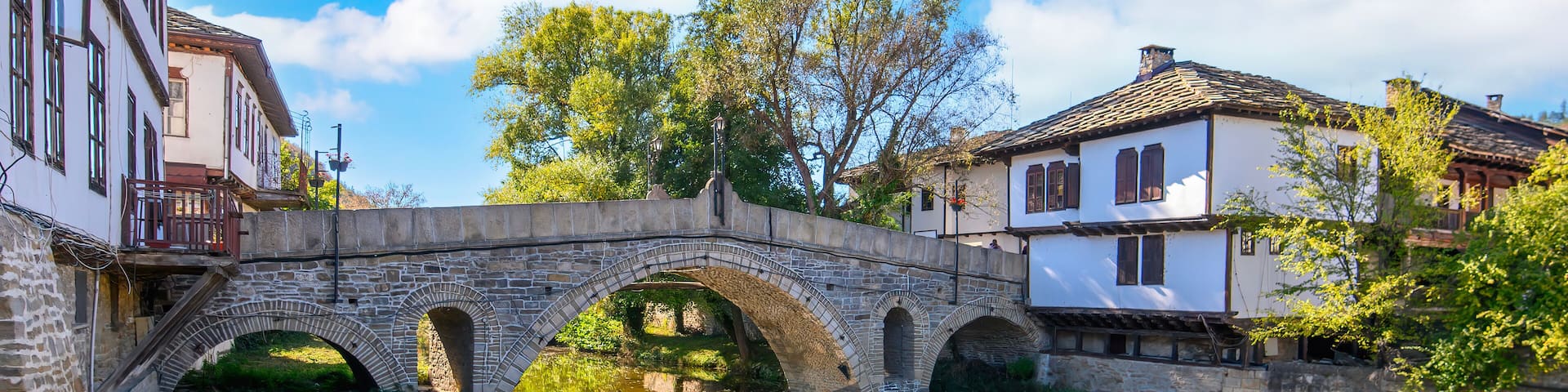 Panorama of Tryavna, Bulgaria. The old Stone Arch Bridge in the old town in the architectural traditional complex. Region of Gabrovo. National revival Bulgarian architecture.