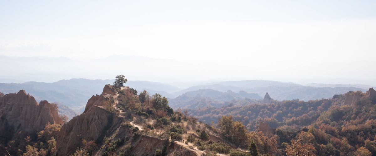 A mountainous landscape with rocky outcrops and a clear sky.