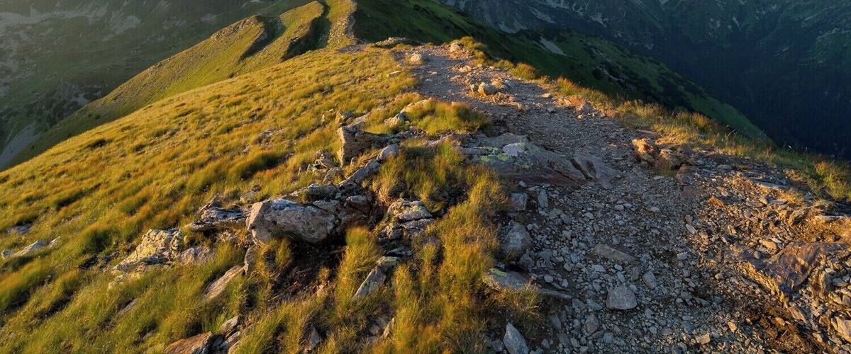 A mountain landscape with rocky terrain and grassy slopes.