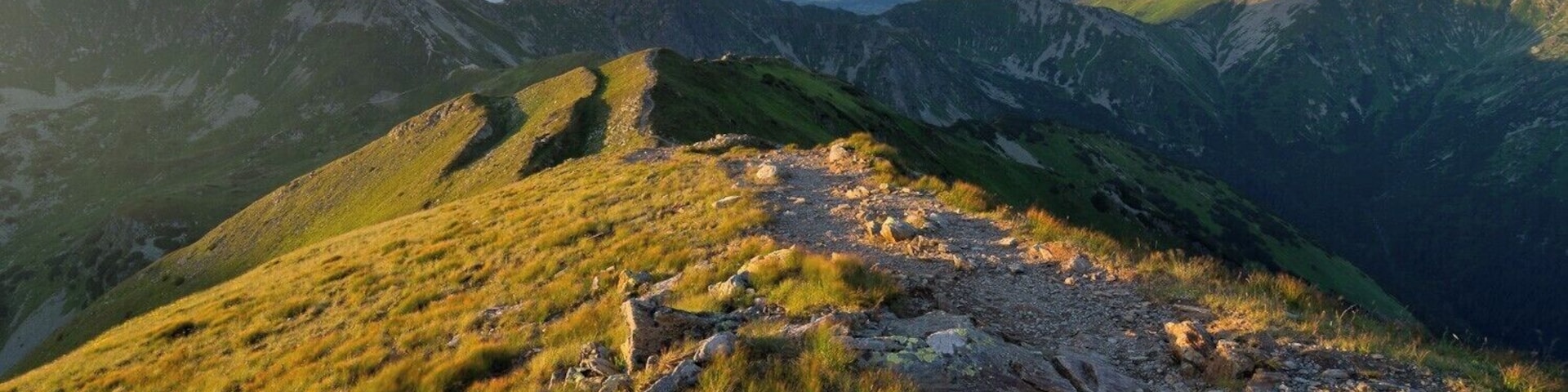A mountain landscape with rocky terrain and grassy slopes.