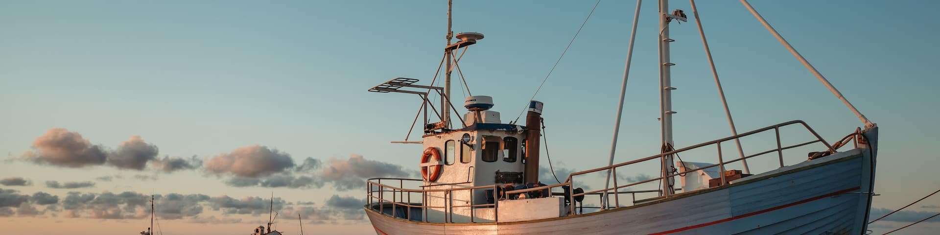Fishing boats on Slettestrand Beach, Denmark, at sunset by the sea